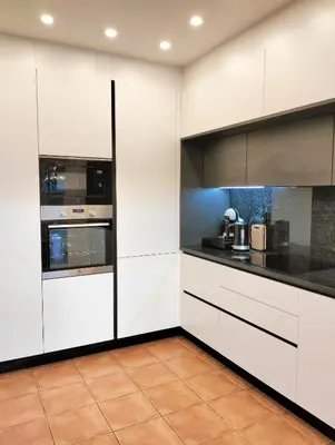 a kitchen with white cabinets and black counter tops at Casa Guna in Aljezur