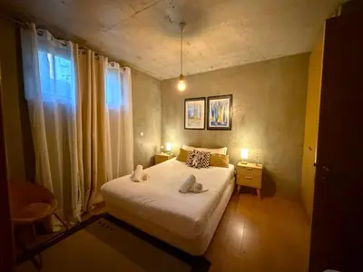 a bedroom with a bed with a black and white comforter at Porto Santo Balcony View House in Porto Santo
