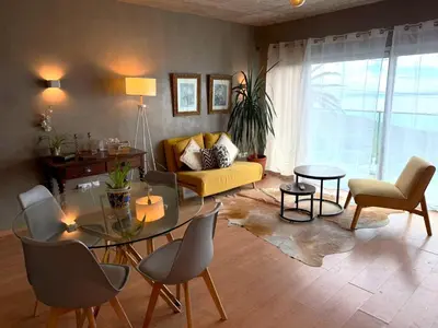 a living room with a yellow chair and a table at Porto Santo Balcony View House in Porto Santo