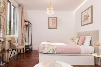 a white bedroom with a bed and a chandelier at Rochinha Cozy Home in Funchal