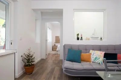 a living room with a gray couch with colorful pillows at Rochinha Cozy Home in Funchal