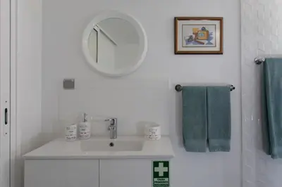 a bathroom with a sink and a mirror and towels at Rochinha Cozy Home in Funchal