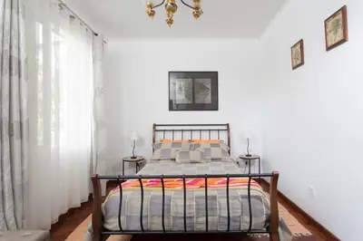 a bedroom with a bed and a chandelier at Rochinha Cozy Home in Funchal