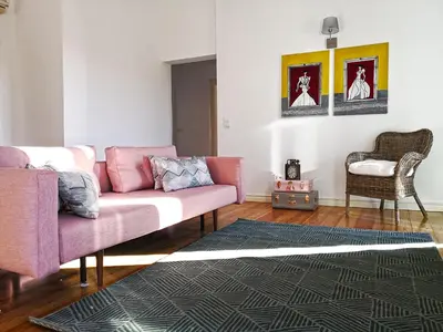 a living room with a pink couch and a rug at Travellers Pearl by Storytellers in Funchal