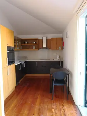 a kitchen with wooden floors and a table in a room at Travellers Pearl by Storytellers in Funchal