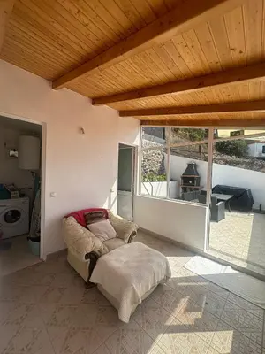 a living room with a chair and a large window at The Hill View House in Funchal
