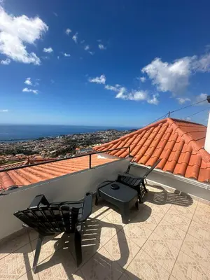 a balcony with two chairs and a view of the ocean at The Hill View House in Funchal