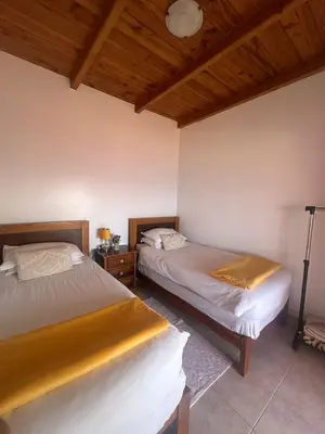 a bedroom with two beds and a wooden ceiling at The Hill View House in Funchal