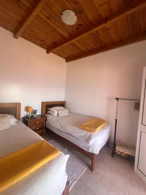 a bedroom with two beds and a wooden ceiling at The Hill View House in Funchal