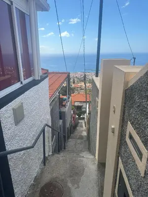 an alleyway between two buildings with a view of the ocean at The Hill View House in Funchal
