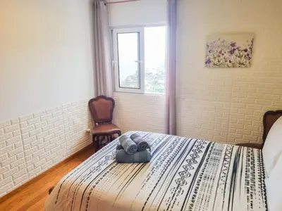 a bedroom with a bed with a towel on it at Loreto Rose, Panoramic Ocean and Mountain View in Arco da Calheta