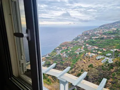 a view of the ocean from a window at Loreto Rose, Panoramic Ocean and Mountain View in Arco da Calheta