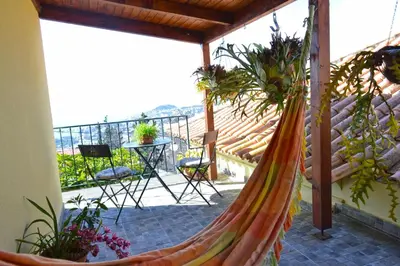 a hammock on a balcony with a table and chairs at Bela Vista in Funchal