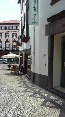 a street with tables and umbrellas in front of a building at Residencial Chafariz /Queimada in Funchal