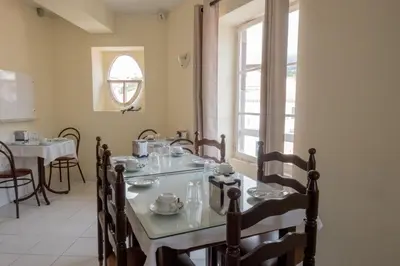 a dining room with a table and chairs and a window at Residencial Chafariz /Queimada in Funchal