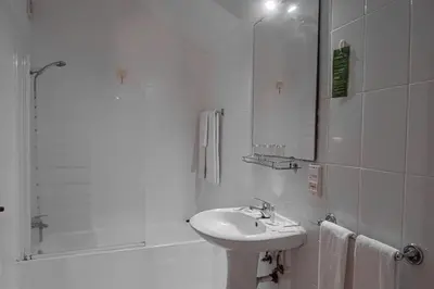 a white bathroom with a sink and a shower at Residencial Chafariz /Queimada in Funchal