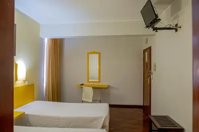 a hotel room with a bed and a mirror at Residencial Chafariz /Queimada in Funchal