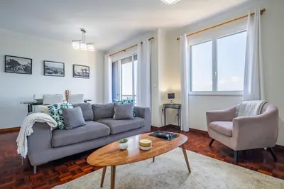 a living room with a couch and a table at Sea View - By WeHost in Câmara de Lobos