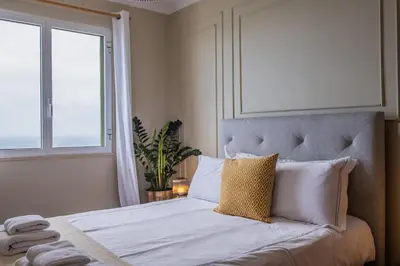 a bedroom with a bed with white sheets and pillows at Sea View - By WeHost in Câmara de Lobos