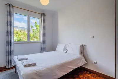 a white bed in a room with a window at Sea View - By WeHost in Câmara de Lobos