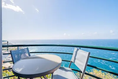 a table and chairs on a balcony overlooking the ocean at Sea View - By WeHost in Câmara de Lobos