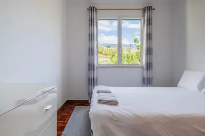 a bedroom with a bed and a window at Sea View - By WeHost in Câmara de Lobos