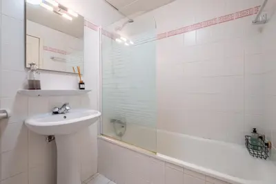 a white bathroom with a sink and a shower at Sea View - By WeHost in Câmara de Lobos