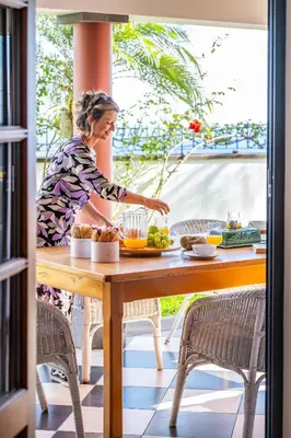 a woman preparing food on a table on a patio at Vila Botânica - By WeHost in Funchal