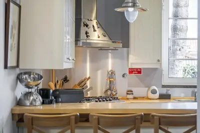 a kitchen with white cabinets and a stove top oven at Vila Botânica - By WeHost in Funchal