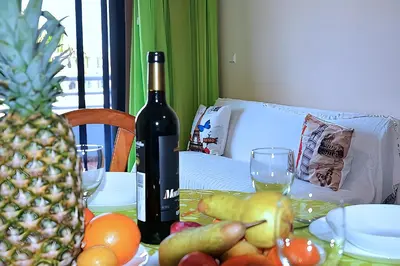 a table with a bottle of wine and a pineapple at Your Home In Madeira III in Funchal