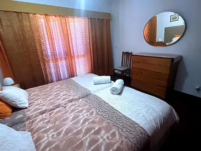 a bedroom with a large bed and a mirror at Your Home In Madeira III in Funchal
