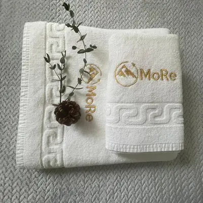 a white towel with the word more on it at Modern & Recycled Guest House in Machico