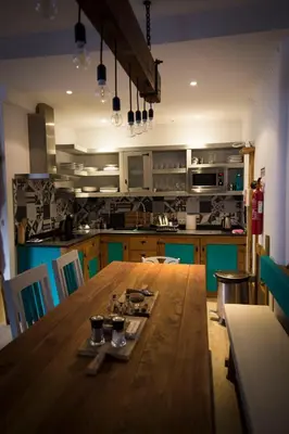 a kitchen with a long wooden table in a room at Modern & Recycled Guest House in Machico