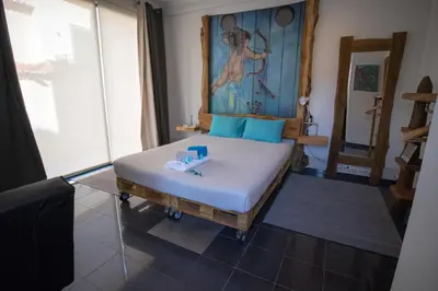 a bedroom with a bed with blue pillows at Modern & Recycled Guest House in Machico