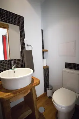 a bathroom with a white sink and a toilet at Modern & Recycled Guest House in Machico