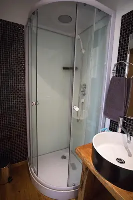a shower with a glass door next to a sink at Modern & Recycled Guest House in Machico
