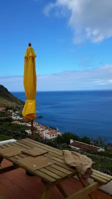 a yellow umbrella sitting on top of a wooden table at Casa da Fajãzinha in Vila do Porto