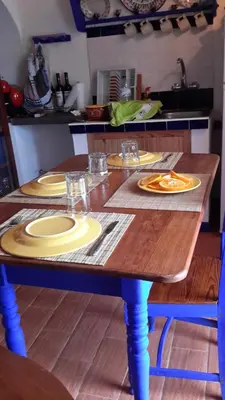 a wooden table with plates on it in a kitchen at Casa da Fajãzinha in Vila do Porto