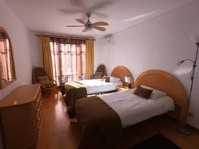 a hotel room with two beds and a ceiling fan at Marina Club Apartment in Funchal