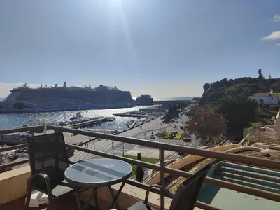 a balcony with a table and chairs and a cruise ship at Marina Club Apartment in Funchal