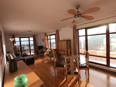 a living room with a ceiling fan and a table and chairs at Marina Club Apartment in Funchal