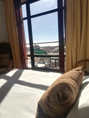 a bed with a pillow in front of a window at Marina Club Apartment in Funchal