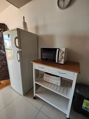 a microwave on a table next to a refrigerator at Marina Club Apartment in Funchal