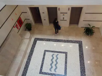 a woman walking down a hallway in a building at Marina Club Apartment in Funchal