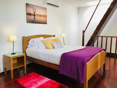 a bedroom with a bed with a purple blanket on it at Casa do Lugar da Ribeira in Ribeira Brava