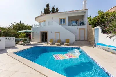 a villa with a swimming pool in front of a house at CoolHouses Algarve, Casa Redonda, V3 Lagos in Lagos