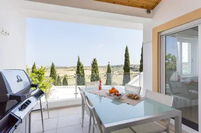 a kitchen with a table and a view of the ocean at CoolHouses Algarve, Casa Redonda, V3 Lagos in Lagos