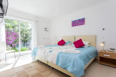 a white bedroom with a bed and a window at CoolHouses Algarve, Casa Redonda, V3 Lagos in Lagos