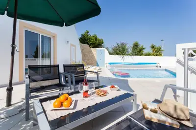 a patio with a table and an umbrella and a pool at CoolHouses Algarve, Casa Redonda, V3 Lagos in Lagos