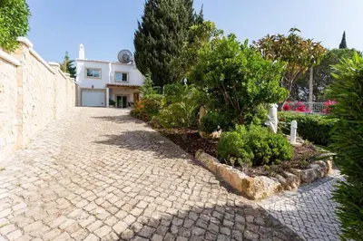 a brick driveway with trees and bushes in front of a house at CoolHouses Algarve, Casa Redonda, V3 Lagos in Lagos